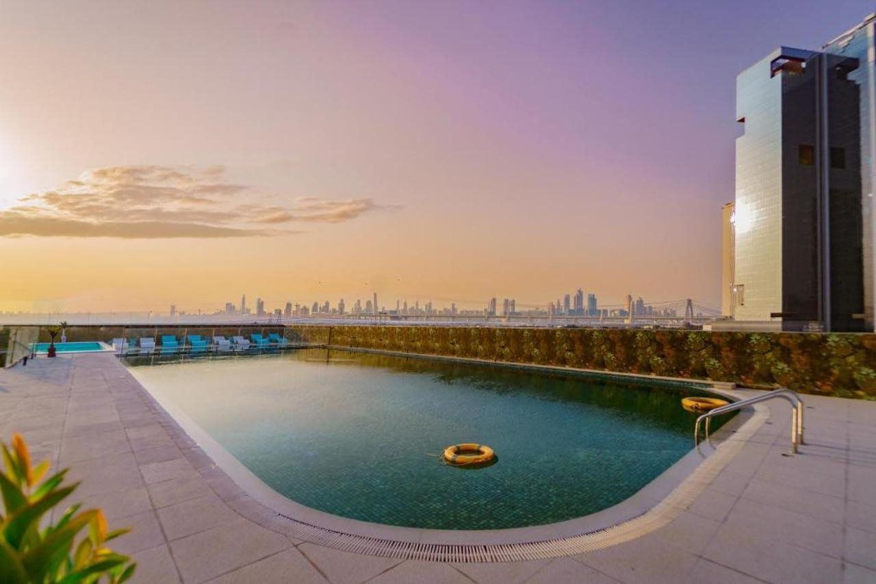 A rooftop pool with clear views of a city skyline during sunset.