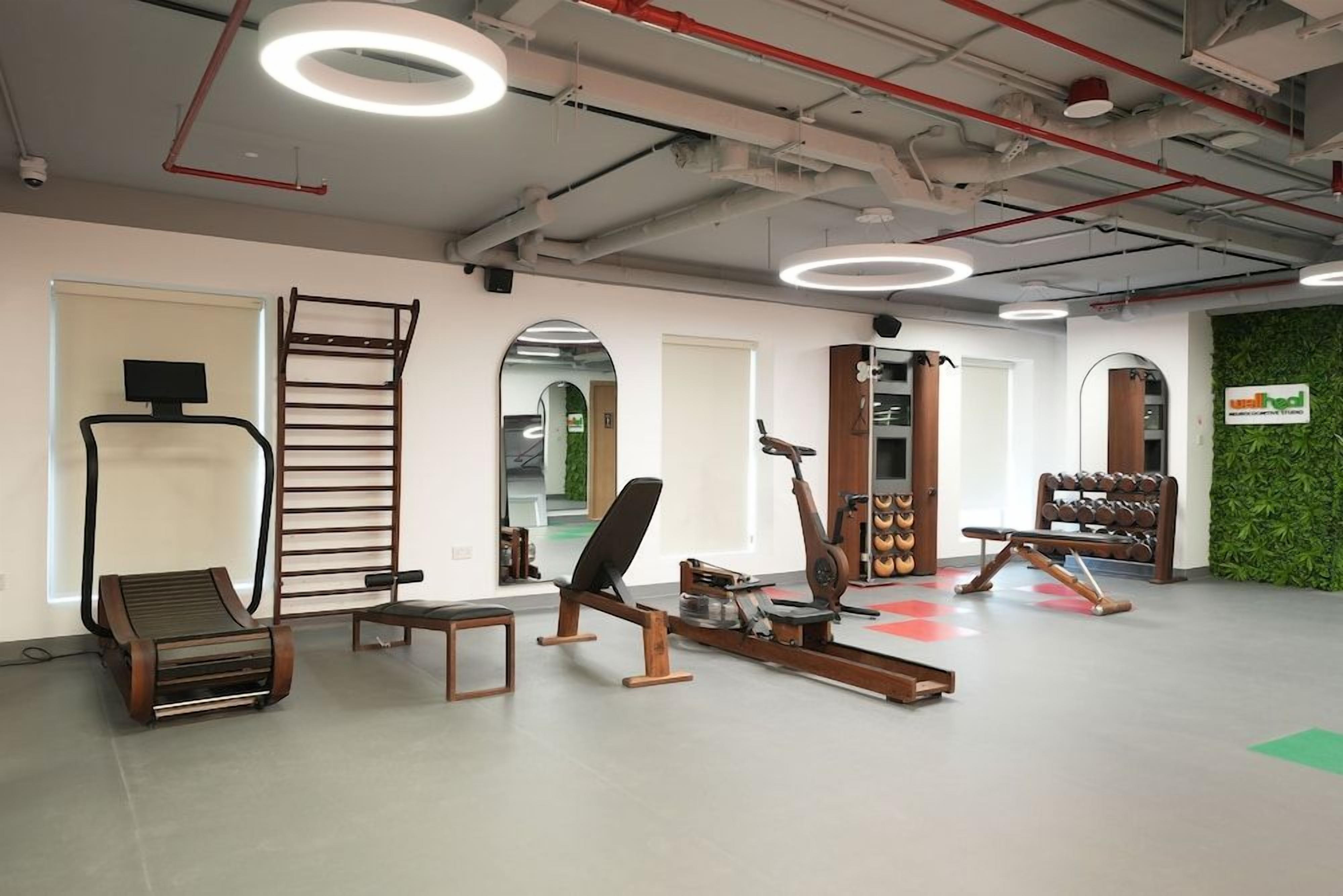 A gym with exercise equipment, a whiteboard, and a green wall.