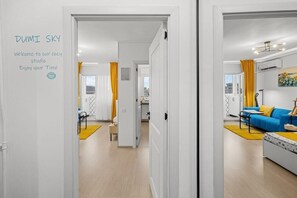 Ein modernes Interieur mit einer sichtbaren Tür zu einem Wohnbereich, einem Sofa und einem Couchtisch.