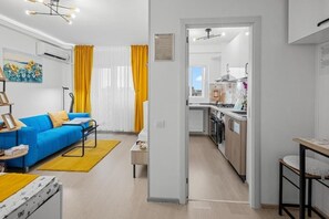 A modern apartment with a living room, kitchen, and dining area. - DUMI SKY - Modern Studio & Balcony & Metro - Easy Access to City Center (București)