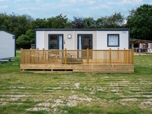 A mobile home with a fenced deck, a door, and a window. - Nice Family Caravan in the Countryside (Kaprijke)