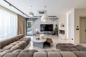 Ein modernes Wohnzimmer mit einer Couch, einem Couchtisch und einem Fernseher.