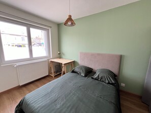 Une chambre à coucher avec un lit, un bureau et une fenêtre.