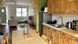 Eine Küche mit Holzausstattung, einem Edelstahlkühlschrank und einer Kaffeemaschine.