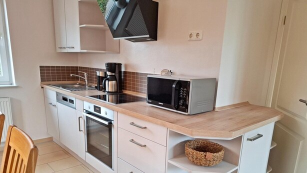 A kitchen with a microwave, coffee maker, and a sink. - Deichhuus in Nessmersiel (Dornum)
