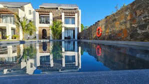 A modern hotel with a swimming pool, stone walls, and a lifebuoy. - Marvelous 3-bedroom apartment with AC in Grand Baie (Grand Baie)