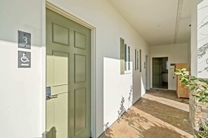 A hallway with a green door, a wheelchair accessibility sign, and a number '3' sign. - Bella Notte by the beach Studio 3 (Pleasure Point)