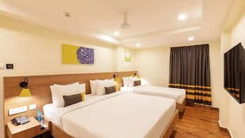 A hotel room with a large bed, two bedside tables, a desk, a chair, a flat-screen TV, and a ceiling fan.