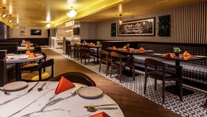 A restaurant with round tables, rectangular booths, and a patterned floor. - Istay Hotels Jubilee Hills Hyderabad by Othpl (Hyderabad)