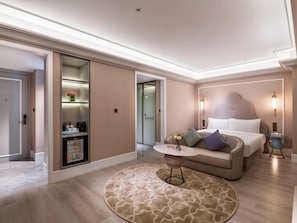 A modern hotel room with a bed, a round coffee table, a sofa, a small table with a vase, and a built-in wardrobe. - Mercure Shanghai Waigaoqiao (Shanghai)