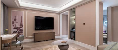 Una sala de estar moderna con un televisor de pantalla plana, un comedor con mesa y sillas, y una zona de estar acogedora con sofá y cojines.