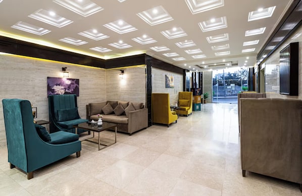 Un hall d’entrée moderne avec un canapé, des fauteuils et une table basse.