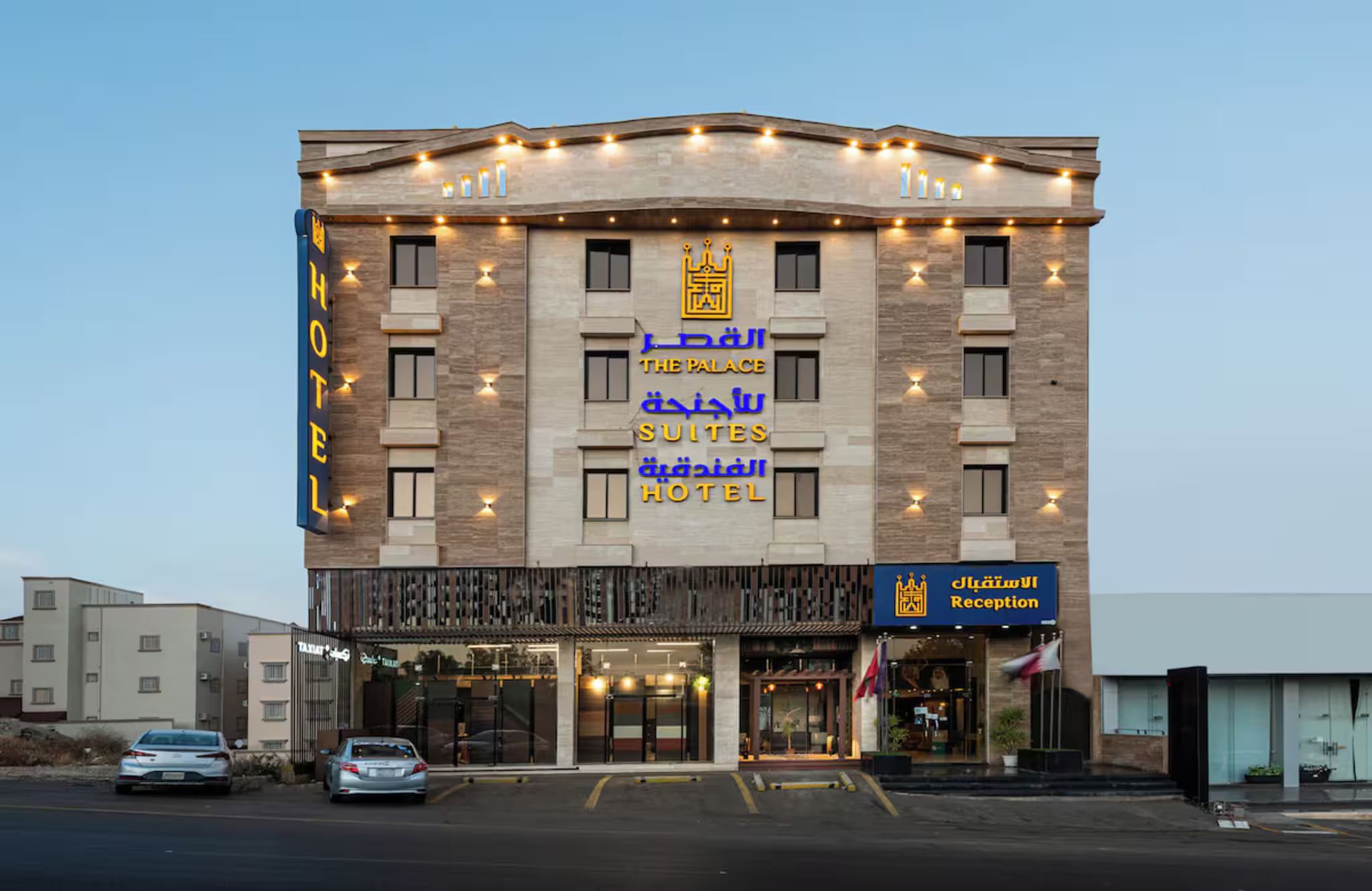 A hotel with a sign indicating 'The Palace Suites Hotel' and a reception area.