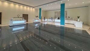 A spacious lobby with a polished marble floor, multiple reception desks, and a large wall mural. - Laguna Holiday Resort Corfu (Corfu)