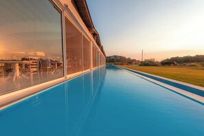 A swimming pool with a glass enclosure, a view of the landscape, and a clear sky. - Laguna Holiday Resort Corfu (Corfu)