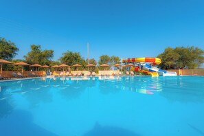 A swimming pool with lounge chairs and a water slide. - Laguna Holiday Resort Corfu (Corfu)