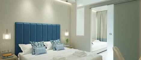 Une chambre d’hôtel moderne, dotée d’un grand lit, de tables de chevet, d’un bureau et donnant sur le couloir.