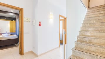 Interior de un hotel con baño, escalera y pasillo.