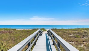 A wooden boardwalk leading to a beach with a clear blue sky. - Sand Dollar Sunrise beachfront 2-bedroom condo - Pet friendly - 2-month minimum (Cocoa Beach)