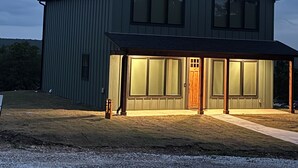 En stor, etetagers bygning med et saddeltag og en overdækket veranda.