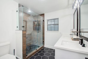 A modern bathroom with a glass-enclosed shower, a white sink, and a large mirror. - 3 Beds Houston Home, Close NRG Stadium & Rodeo (Houston)