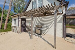 A covered outdoor area with a grill and a stone wall. - Your Rustic Retreat w Backyard Oasis, Pool, Patio (Roanoke)