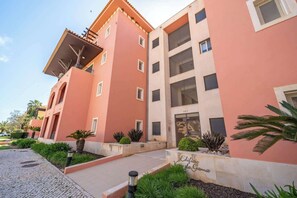 A multi-story building with a red facade, balconies, and a sign reading 'Edificio Villa Gama.' - Sunlit Villa Terraces and Pool in Vilamoura by HostWise (Quarteira)