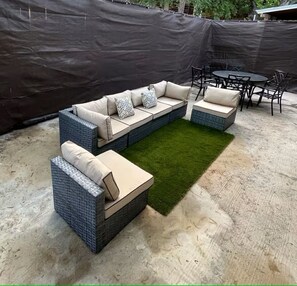 Ein modulares Sofa mit verschiedenen Sitzbereichen und einem kleinen Tisch mit Stühlen.