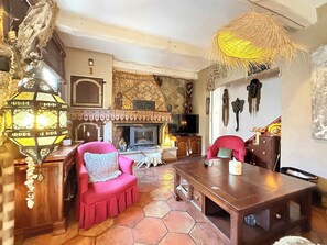 Ein gemütliches Wohnzimmer mit Kamin, Fernseher und Essbereich.