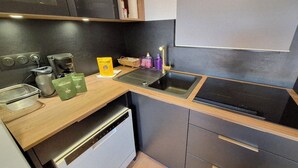 Eine kleine Küche mit Kaffeemaschine, Spüle und Geschirrspüler.