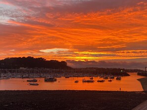 Ein Yachthafen mit vertäuten Booten, ein Gewässer und ein Sonnenuntergangshimmel.