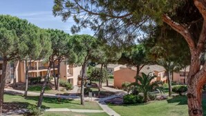 Une cour intérieure avec un chemin, des arbres et des immeubles à plusieurs étages.