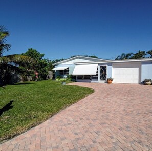 A modern house with a garage, a paved driveway, and a well-maintained lawn.