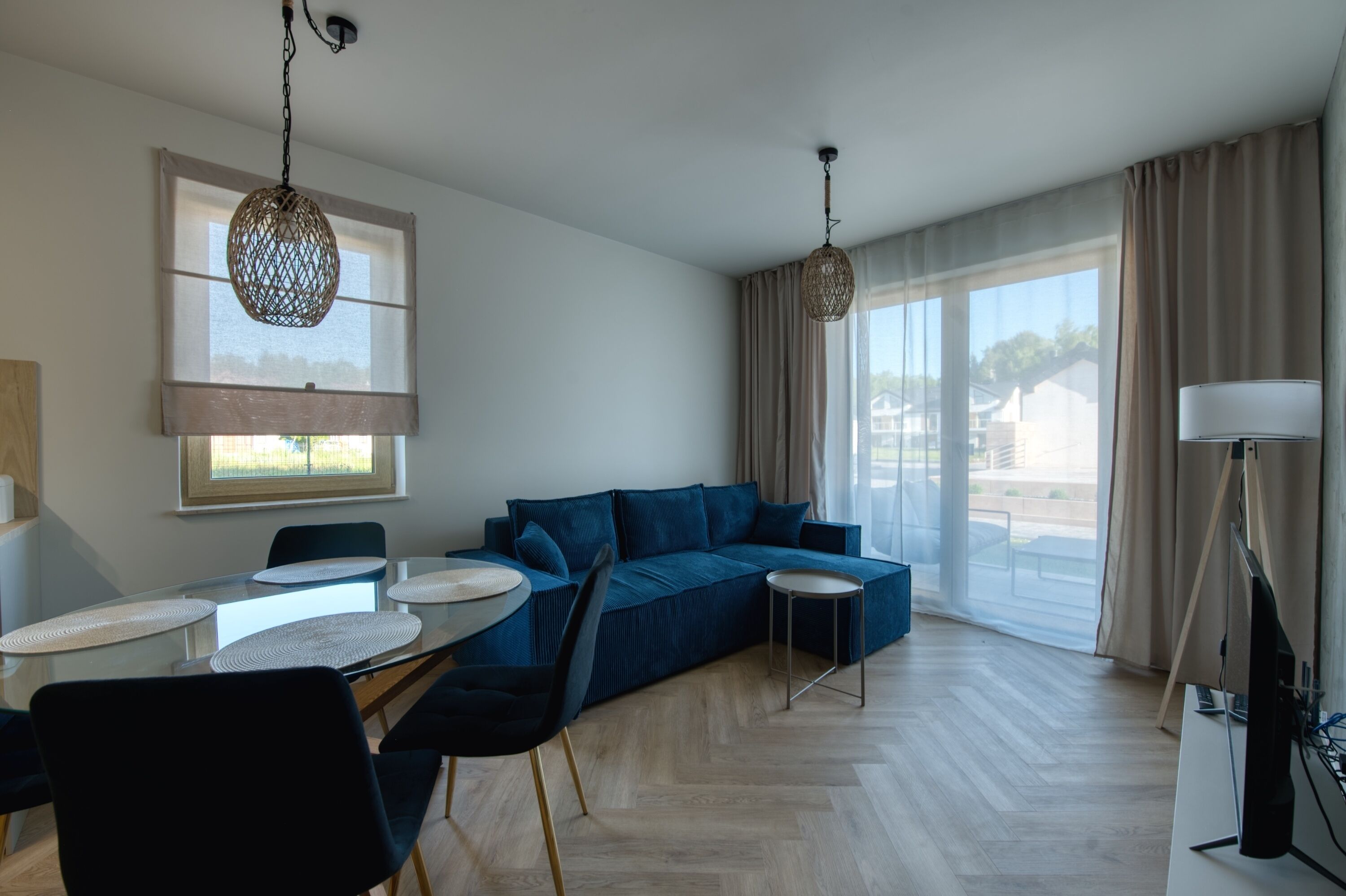 Una sala de estar moderna con un sofá, una mesa de comedor con sillas y un televisor.