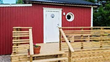 Un edificio rojo con una puerta blanca y un ventanal circular.