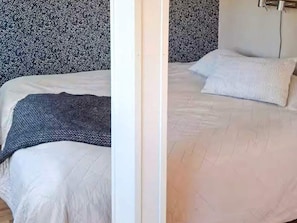 Um quarto com cama, travesseiros e cobertor.