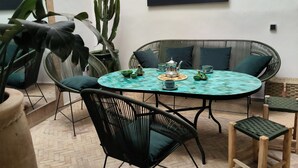 A patio with a round table, black chairs, and a cactus plant. - Riad 3 rooms, medina, Top Location (Marrakech)