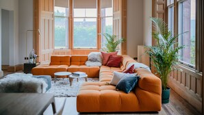 A cozy living room with a sectional sofa, a round coffee table, and a potted plant. - Dun Aluinn  (Aberfeldy)