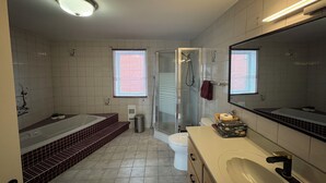 A bathroom with a bathtub, a shower, a toilet, and a sink.