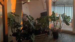 A room with a large mirror, a ceiling fan, and several potted plants. - WORLD CUP READY :- Cozy 1-bedroom modern luxury loft (Harrison)
