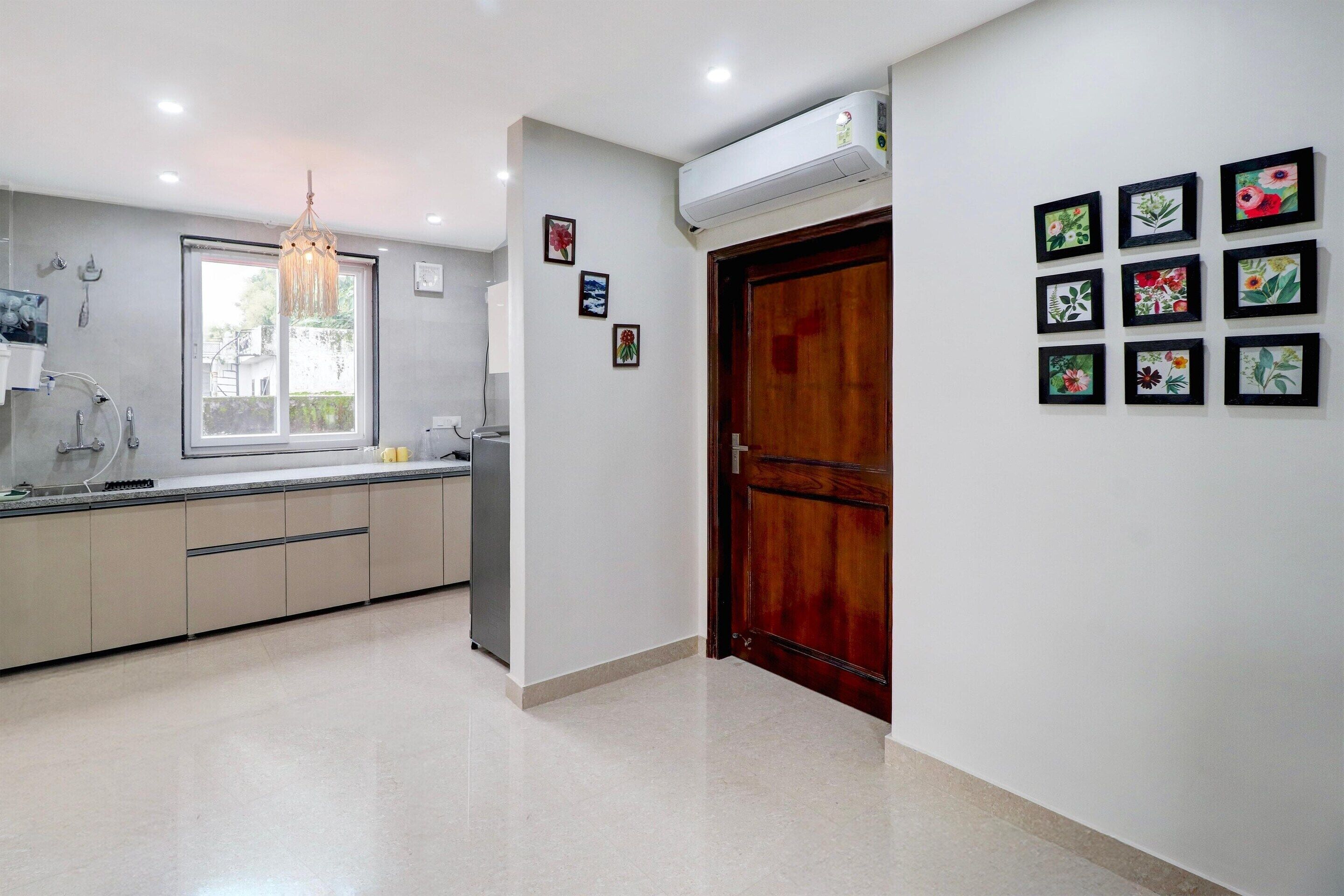 Una cocina moderna con ventana, una lámpara de araña y una puerta de madera.