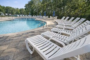 Ein Schwimmbad mit Liegestühlen und Sonnenschirmen.