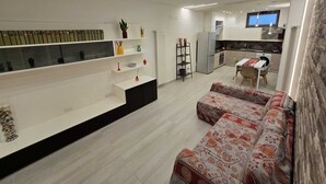 A modern living room with a sofa, a coffee table, and a TV in the background. - Bright and quiet apartment (Pianillo)