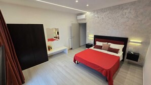 A modern bedroom with a large bed, bedside tables, a mirror, and a wardrobe. - Bright and quiet apartment (Pianillo)