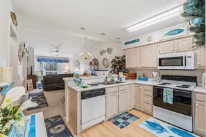 A modern kitchen with white cabinets, a dishwasher, a microwave, and an oven. - Golf Getaway- Pools- Near Beach! (Longs)