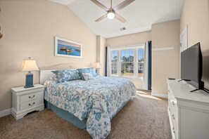 A bedroom with a bed, nightstand, lamp, TV, and a window with a view. - Golf Resort Condo / Pool/Near Broadway Beach (Myrtle Beach)