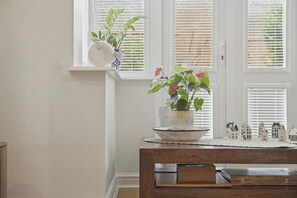 A dining area with a wooden table, a white vase with flowers, and a window with blinds. - NEW!4BR Ideal for Contractors, Driveway, Wifi, M40 (Heathcote)