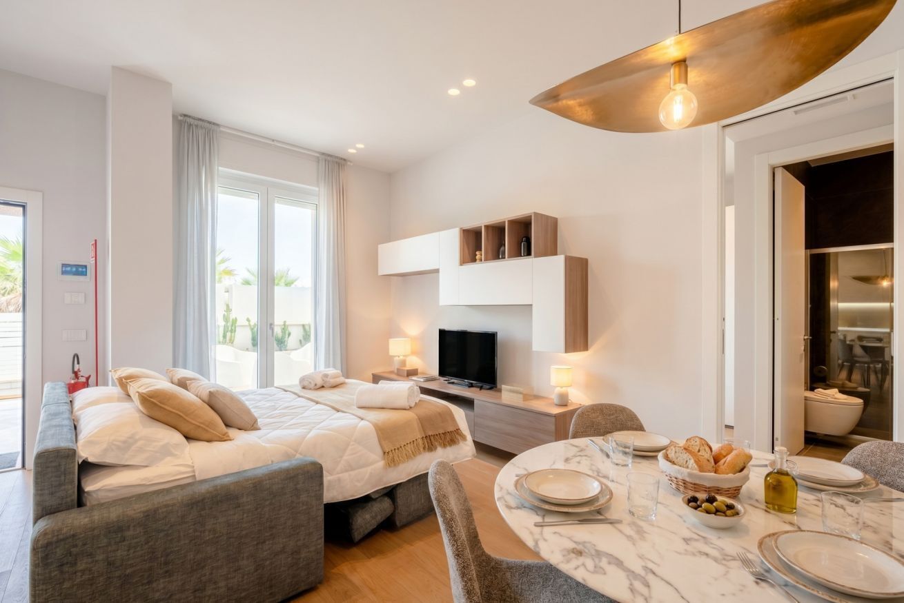 Une chambre d’hôtel moderne équipée d’un lit, d’un coin salon, d’une table à manger et d’un téléviseur.