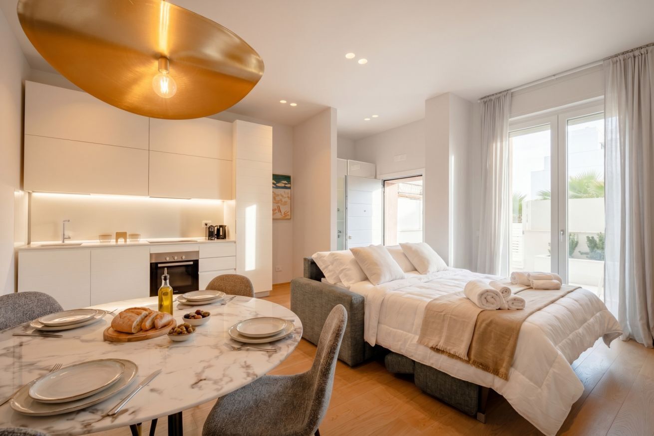 Une chambre d’hôtel moderne dotée d’un coin repas, d’un lit avec vue et d’une cuisine.