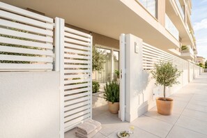 A modern building with a white exterior, a balcony with a white railing, and potted plants. - 7Mari-Modern Comfort Stay (Bari)